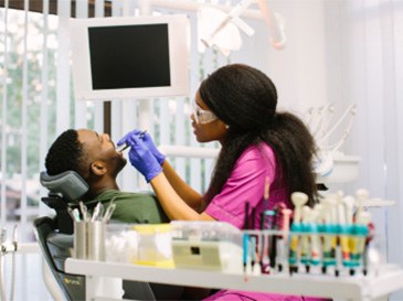 man with dental assistant looking at smile